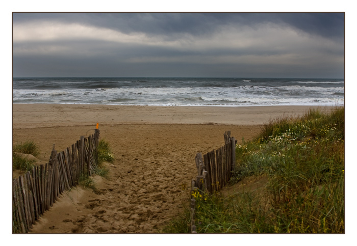 Blick auf das aufw&uuml;hlende Meer und den d&uuml;steren Strand